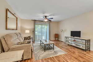 Living room with light wood finished floors and ceiling fan