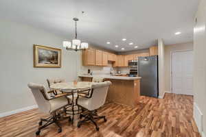 Dining area with light wood finished floors, recessed lighting, and a chandelier