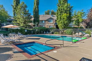 Community pool featuring a hot tub and a patio