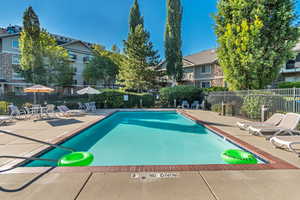 Community pool with a patio and a residential view