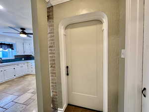 Detailed view of a textured wall, a ceiling fan, and decorative backsplash