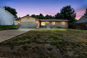 Ranch-style house featuring driveway, brick siding, and an attached garage