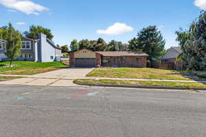 View of front of property featuring driveway, an attached garage, and brick siding