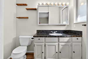 Half bathroom with vanity and dark wood finished floors