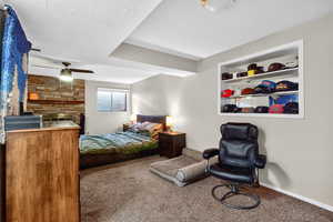 Bedroom featuring carpet, a textured ceiling, and a ceiling fan