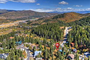Aerial view of property's location with a mountainous background and a forest