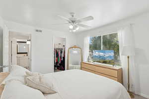 Bedroom featuring a spacious closet, ceiling fan, and carpet floors