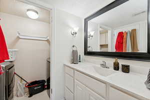 Bathroom featuring a textured ceiling and vanity