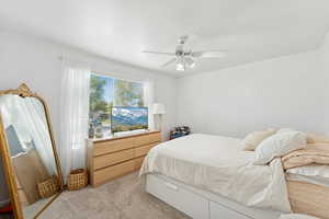 Carpeted bedroom featuring a ceiling fan