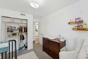 Carpeted bedroom with a closet