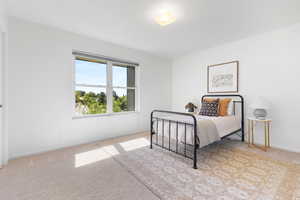 Bedroom with light colored carpet and baseboards