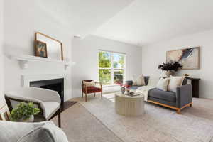 Carpeted living area featuring a fireplace with flush hearth