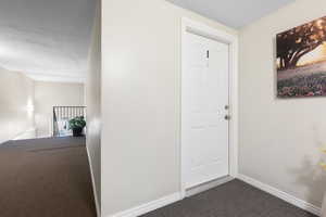 Corridor featuring a textured ceiling and carpet