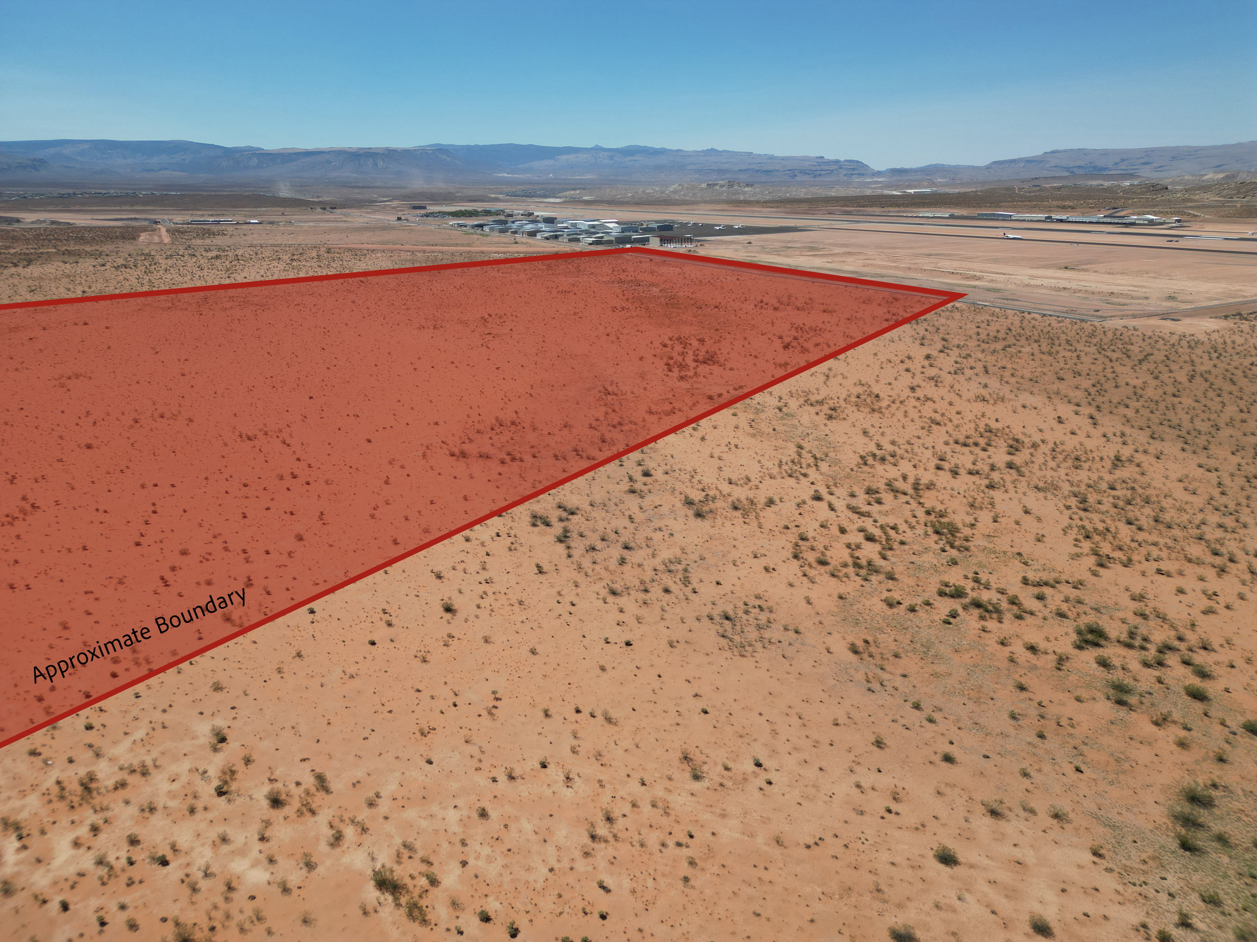 Aerial view of property and surrounding area featuring mountains and property parcel outlined