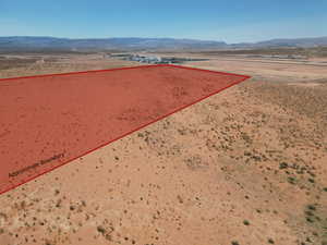 Aerial view of property and surrounding area featuring mountains and property parcel outlined