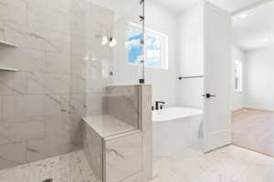 Full bathroom with a freestanding tub, light marble finish floors, a marble finish shower, and recessed lighting
