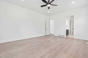 Unfurnished bedroom featuring light wood-style flooring, a ceiling fan, recessed lighting, and ensuite bath