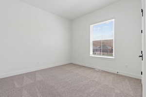 Unfurnished room with light colored carpet and baseboards