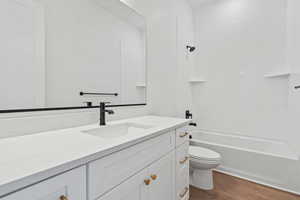 Full bathroom with shower / bathtub combination, dark wood-type flooring, and vanity