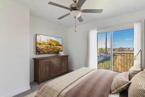 Carpeted bedroom with access to exterior and a ceiling fan. Staged