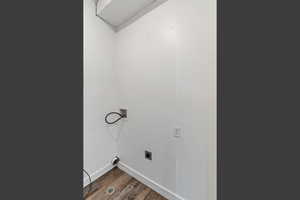 Laundry area with dark wood-style floors, hookup for a washing machine, and hookup for an electric dryer