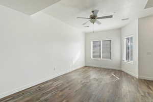 Unfurnished room with dark wood-type flooring, ceiling fan, and a textured ceiling