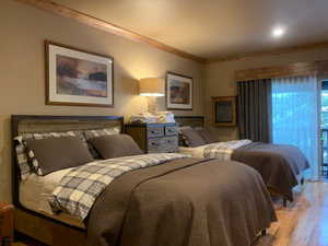 Bedroom featuring wood finished floors and ornamental molding