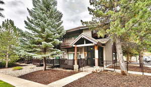 View of front of house with a balcony and board and batten siding