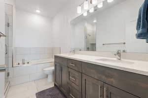 Bathroom featuring light tile patterned flooring, a shower stall, double vanity, and a bath