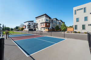 View of basketball court with community basketball court, a tennis court, and a residential view