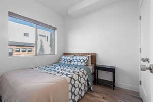 Bedroom with hardwood / wood-style flooring and baseboards
