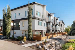 View of front of home with a residential view, stucco siding, a fenced front yard, and a balcony