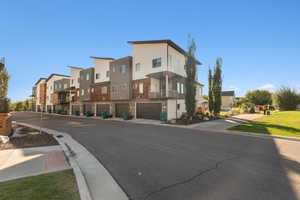 View of asphalt road with a residential view and curbs