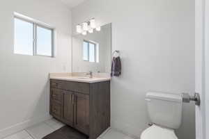 Half bath featuring light tile patterned flooring and vanity