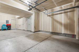 Garage featuring electric panel and a garage door opener