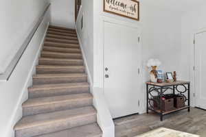 Stairway featuring wood finished floors