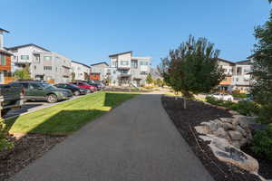 View of property's community featuring uncovered parking, a lawn, and a residential view