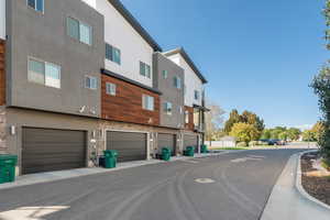 Back of house with stone siding, a residential view, and stucco siding