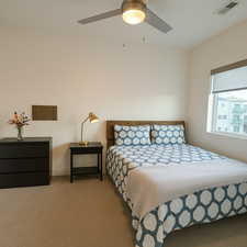 Carpeted bedroom featuring a ceiling fan and baseboards