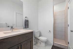 Full bath with light tile patterned floors, vanity, and a stall shower