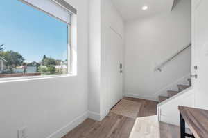 Foyer with light wood-style floors, recessed lighting, and stairway