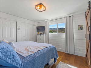 Primary bedroom with  ensuite bathroom and a barn door, hardwood / wood-style floors, two closets