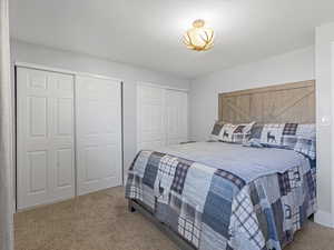 Bedroom with two closets and carpet flooring