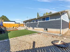 Back of house with a wooden deck, a fire pit, and a patio area
