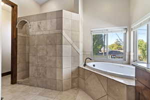Bathroom with a garden tub, a tile shower, and tile patterned flooring