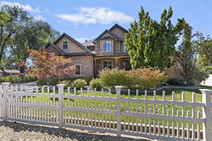 Craftsman inspired home featuring stone siding, stucco siding, and covered porch
