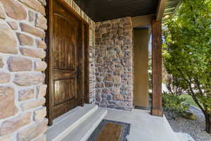 Property entrance with stone siding and a porch