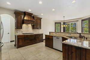 Kitchen featuring decorative backsplash, light stone countertops, recessed lighting, appliances with stainless steel finishes, and pendant lighting