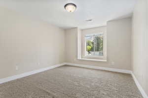 Carpeted empty room featuring baseboards