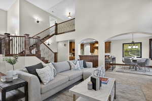 Tiled living room with a high ceiling and stairs